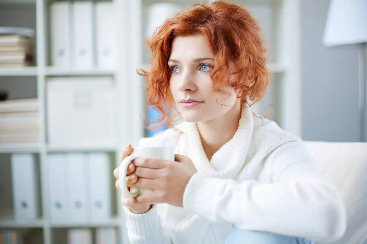 femme assise sur un canapé avec une tasse pour un remède naturel contre l'anxiété