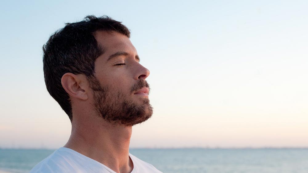 homme relax qui respire face à la mer