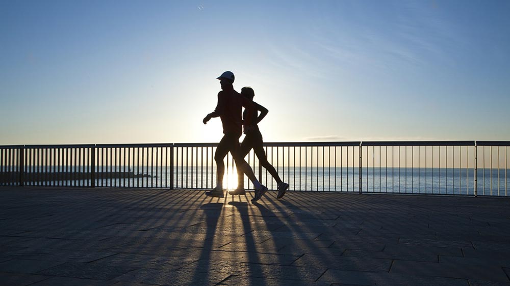 un couple qui fait du jogging le long de la mer